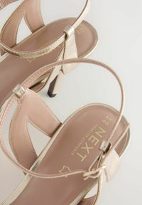 Blassrosa, verzierte Riemchen-Sandalen mit hohen Absätzen und metallischen Akzenten, mit einem filigranen Design und strukturiertem Fußbett. Markenlogo auf der Innensohle.