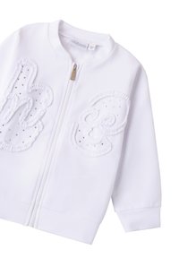 Giacca bianca con zip caratterizzata da tessuto testurizzato, grandi lettere ricamate, accenti luccicanti e polsini a coste. Design minimalista.