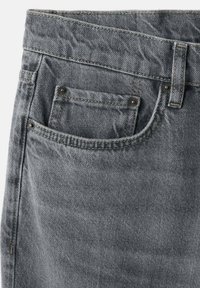 Jeans de mezclilla gris con un acabado texturizado, un bolsillo frontal con remaches de metal y costuras a contraste a lo largo de las costuras.