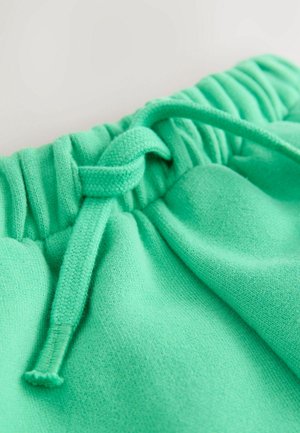 Pantaloni corti jogger verde menta realizzati in un tessuto morbido e testurizzato. Presentano una vita arricciata e un dettaglio con cordoncino annodato.