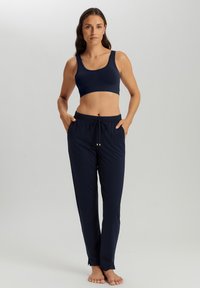 Marineblå komfortabel sports-bh med brede stropper og matchende løstsiddende joggers med elastisk talje og snor. Glat stoftekstur.