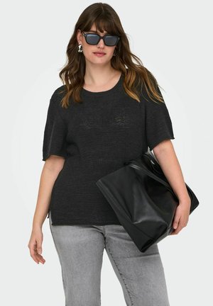 Maglione nero a maniche corte in maglia con scollo rotondo, abbinato a jeans grigio chiaro e una borsa tote in pelle nera.