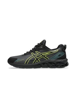 Zapato deportivo negro con parte superior de malla, acentos en amarillo neón y suela texturizada. Cuenta con un talón acolchado y una punta reforzada para mayor soporte.