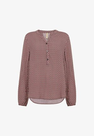 Bluzica z dolgimi rokavi s krožnim izrezom, ki ima geometrijski rdeč, črn in bel vzorec, zapiranje na gumb in ukrivljen rob.