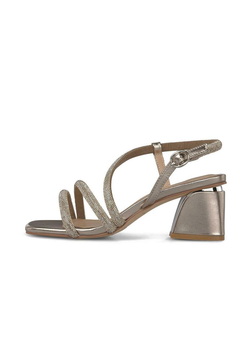 Sandal de punta abierta metálico beige con tres tiras delgadas adornadas con joyas, hebilla en el tobillo y tacón cuadrado con un diseño geométrico moderno.