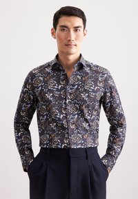 Lange mouwen shirt in donkerblauw met een bloemenpatroon in wit, lichtblauw en bruin. Heeft een button-down kraag en een aansluitende pasvorm.