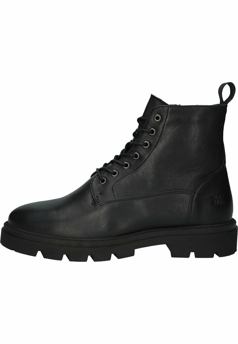 Botte de combat en cuir noir à lacets avec semelle crantée épaisse et languette au talon, vue de côté.