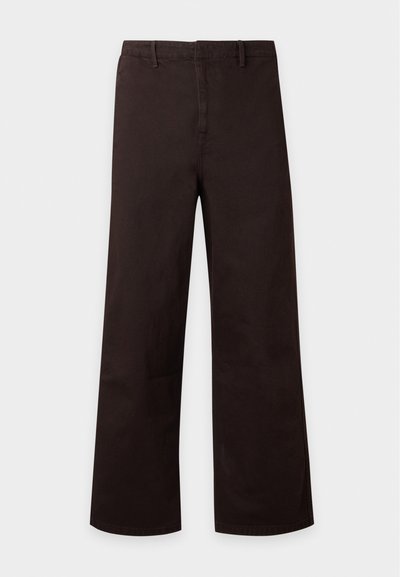 Pantalon marron foncé à jambes droites avec passants pour ceinture et fermeture éclair à l’avant, présenté sur un fond clair uni.