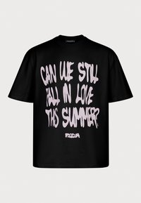 Czarna, oversize koszulka z krótkim rękawem z jasnoróżowym napisem "Czy nadal możemy zakochać się tego lata?" oraz małym logo "PGDGR" poniżej.