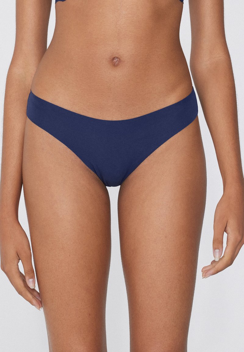 Bas de bikini bleu marine en tissu lisse, doté d'un design taille basse et d'une couverture minimale sur les côtés et le dos.