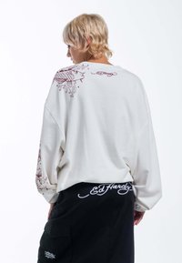 Witte oversized sweatshirt van katoen met een rode grafische vissenontwerp op de achterkant en het "Ed Hardy" logo op de onderste zoom. Ontspannen pasvorm.
