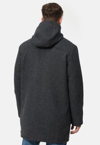 Cappotto grigio scuro in misto lana con cappuccio, taglio dritto e cuciture minimaliste. Presenta maniche lunghe e tasche laterali.