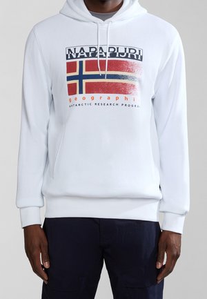 Mies, jolla on valkoinen huppari, jossa on tummansinisen, punaisen ja beigen lippukuva sekä edessä teksti "NAPAPIJRI geographic Antarctic research program".