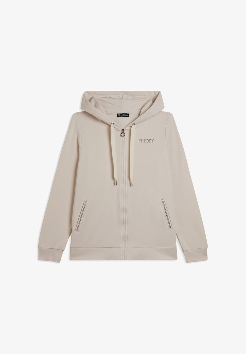 Haut zippé beige avec capuche à cordon, poches zippées sur les côtés et logo "FREDDY" dans une finition métallique subtile sur la poitrine. Texture de tissu douce.
