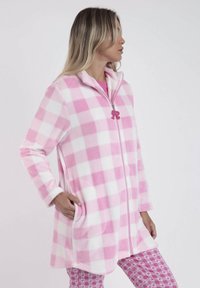 Bata de felpa a cuadros rosa y blanca con cierre de cremallera frontal, cuello alto y bolsillos laterales. Incluye un detalle de tirador de cremallera en forma de caballito de mar rosa.