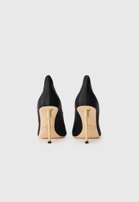 Black satin high heels with pointed toes and a slim gold heel. The heels feature a curved design and a smooth texture.