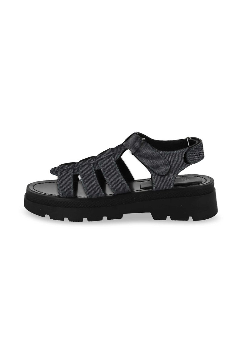 Black denim sandals with multiple crisscross straps, a round toe design, and a chunky black rubber sole featuring tread patterns.