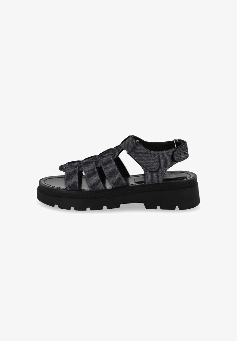 Black denim sandals with multiple crisscross straps, a round toe design, and a chunky black rubber sole featuring tread patterns.