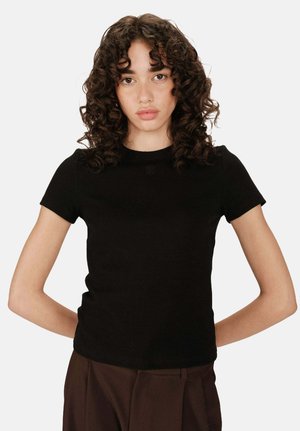 T-shirt noir à manches courtes en tissu côtelé avec une coupe ajustée et un logo brodé discret sur la poitrine. Texture lisse.
