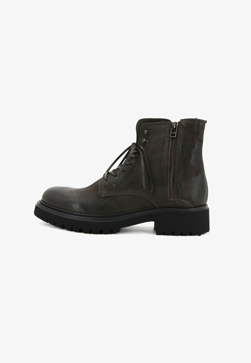 Stivaletto alla caviglia in pelle grigia scura con punta arrotondata, lacci frontali e cerniera laterale. Suola in gomma nera robusta con scanalature profonde per una buona aderenza.