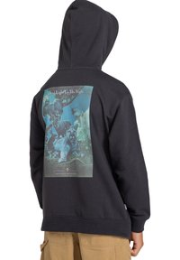 Sudadera negra de algodón, con un gran estampado gráfico colorido en la parte posterior que representa varios animales y árboles. Capucha ajustable.