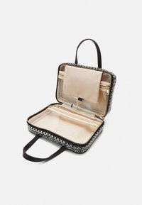 Borsa a fantasia bianco e nero con esterno testurizzato, chiusura con zip, scomparti interni trasparenti e manico per un facile trasporto.