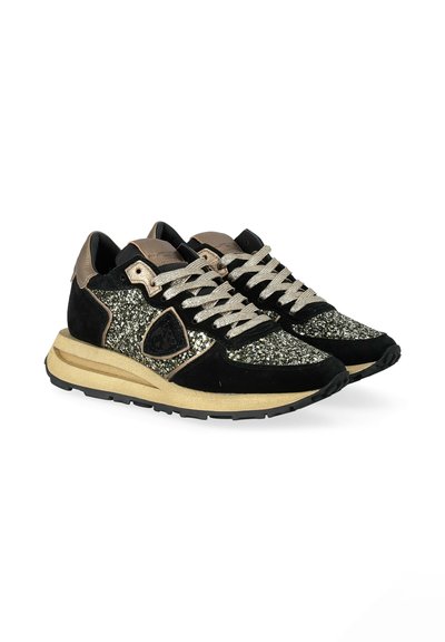 Black and gold sneakers with suede and glitter accents, featuring a textured sole, contrasting laces, and a rounded toe design.
