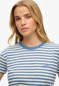 Blauw-wit gestreepte katoenen t-shirt met een geribbelde ronde hals en geborduurd "Superdry" logo op de borst. Casual pasvorm.