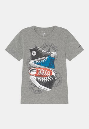 Grå t-shirt med korte ærmer med grafik af fire stabler Converse All Star sneakers i sort, blå, rød og sort farve.