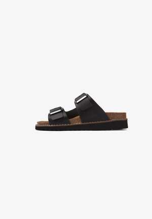 Black sandals with two adjustable straps, metallic buckles, cork footbed, textured rubber sole, and a flat design for comfort.