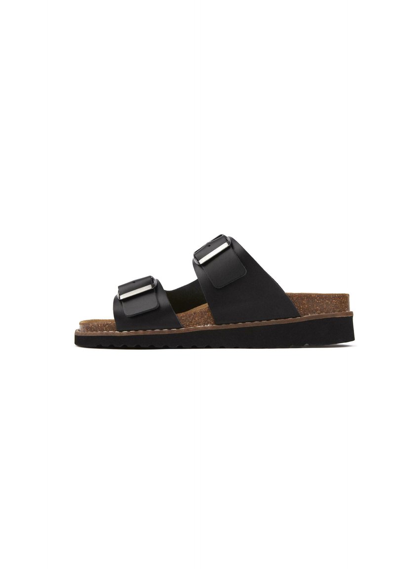 Black sandals with two adjustable straps, metallic buckles, cork footbed, textured rubber sole, and a flat design for comfort.
