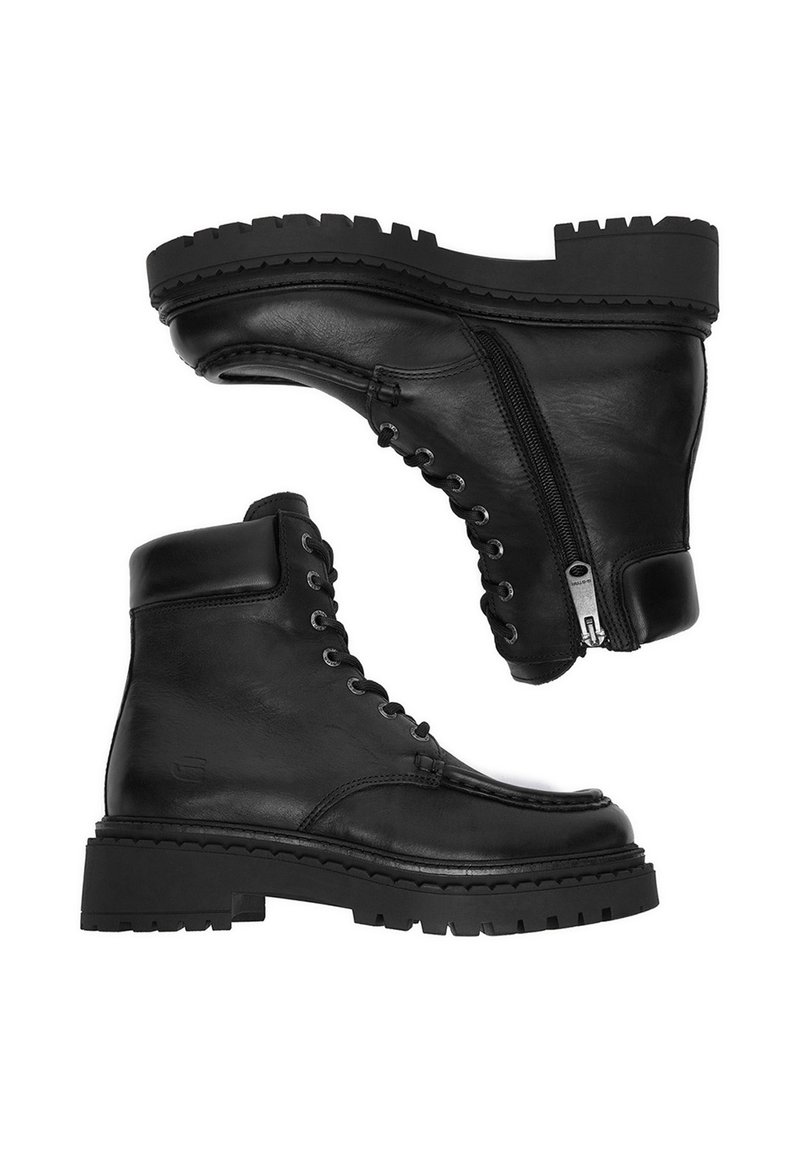 Stivali neri in pelle fino alla caviglia con suole spesse a ragno, stringati nella parte anteriore e con cerniere laterali, mostrati da prospettive laterali e inferiori su sfondo bianco.