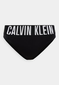 Μαύρο κάτω μέρος μπικίνι με φαρδιά ελαστική ζώνη μέσης που φέρει μεγάλο λευκό κείμενο "CALVIN KLEIN" στο μπροστινό μέρος.