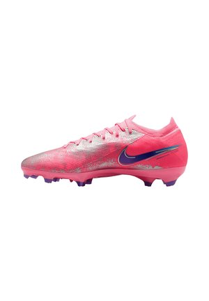 Bota de fútbol Nike baja de color rosa y plata con tacos morados y un logo Nike azul oscuro en el lateral.