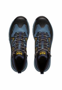 Zapatillas deportivas con una puntera de goma negra, parte superior de malla azul, cordones azul oscuro y acentos amarillos. Diseño resistente para uso al aire libre.