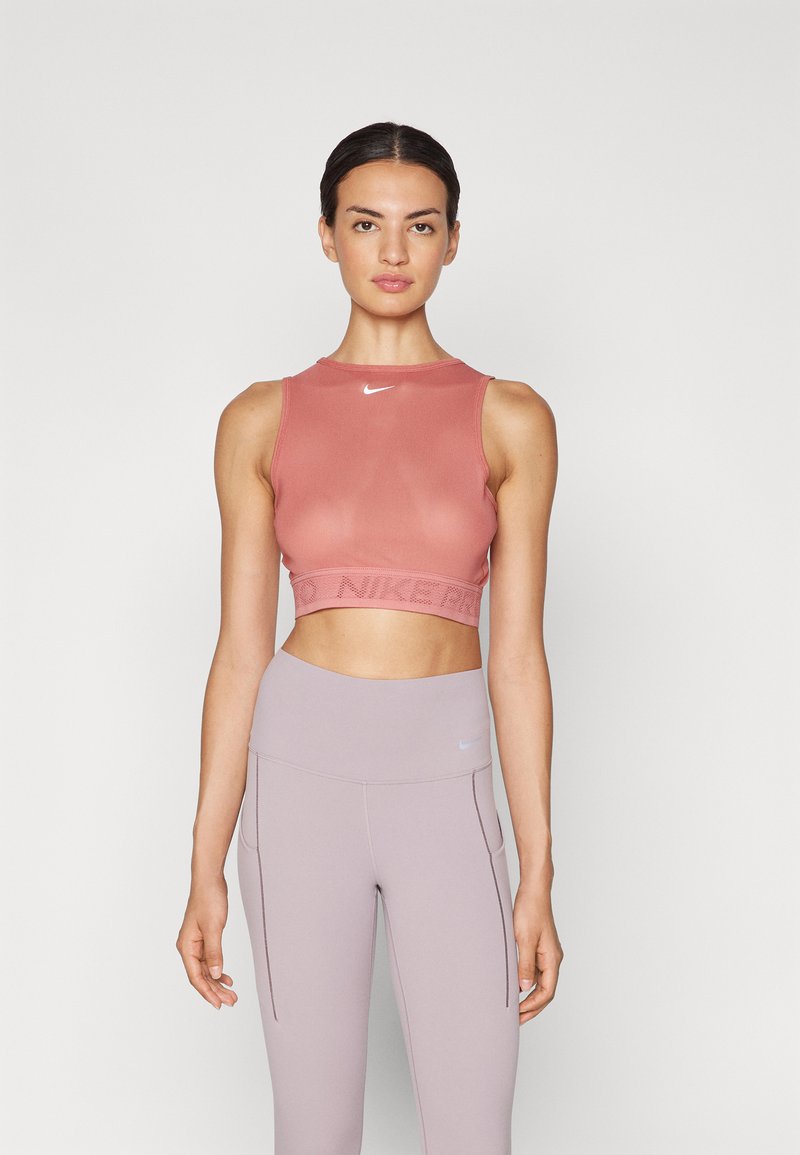 Ροζ αθλητικό κοντομάνικο μπλουζάκι με στρογγυλή λαιμόκοψη και ριμπ λογότυπο Nike, συνδυασμένο με ανοιχτό μωβ ψηλόμεσες κολάν.