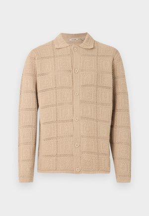 Cárdigan beige de manga larga con botones, patrón cuadrado texturizado y cuello clásico, presentado sobre un fondo liso.