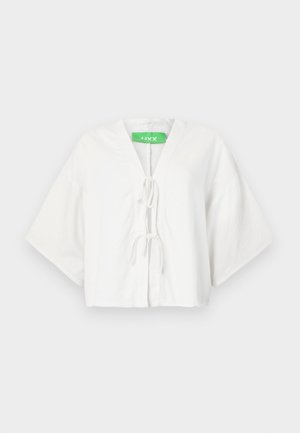 Bela skrčena majica z V-izrezom, kratkimi širokimi rokavi in zategovanjem spredaj. Narejena iz dihalnega materiala. Zelen logotip blagovne znamke viden.