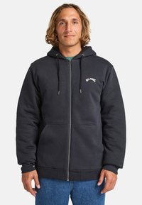 Dark gray zip-up hoodie made of soft fabric, featuring a drawstring hood, front pockets, and a white logo on the chest.