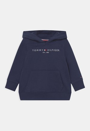 Temno modra kapuca z sprednjim kenguru žepom, ribanim rokavom in robom, z natisnjenim logotipom "TOMMY HILFIGER EST. 1985" na prsih.