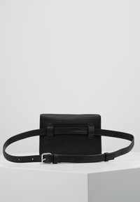 Borsa a cintura nera in pelle con forma rettangolare, parte superiore piatta, dettagli a loop e una tracolla regolabile fissata con una fibbia in argento.