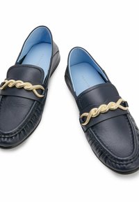 Mocassini da uomo in pelle blu navy con un accento decorativo in catena dorata, punta tonda, cuciture testurizzate e una fodera interna azzurro chiaro.