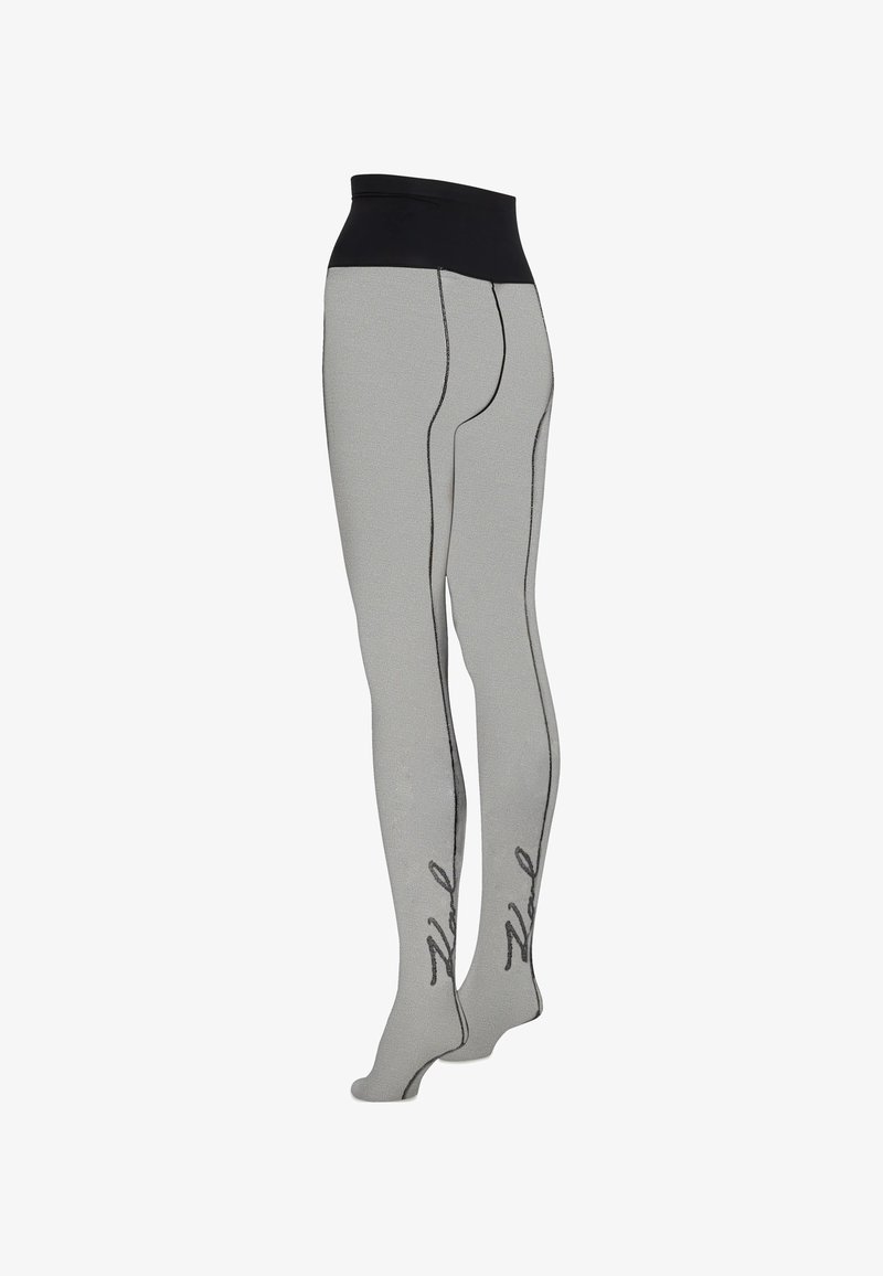 Collants gris clair avec une ceinture noire, des coutures noires le long des jambes et un texte en cursive noire près de la cheville.