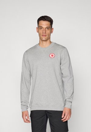 Gray sweatshirt with long sleeves, crew neck, ribbed cuffs, and hem. Features a circular red logo on the left chest. Smooth texture.