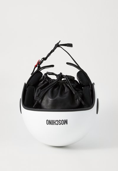 Hvid hjelm med en rund form, udstyret med sorte ørepuder og en snørelæderpose indeni. Brandlogoet er synligt.