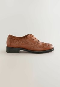 Brown leather oxford shoe with wingtip brogue detailing, round toe, and a low, rectangular black heel. Flat laces and smooth texture.