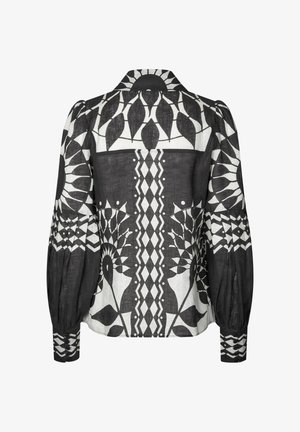 Czarna i biała bluzka w wzory z kołnierzykiem, bufiaste rękawy oraz skomplikowane wzory geometryczne i kwiatowe na całej powierzchni.