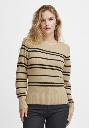 Pull en tricot beige avec des rayures horizontales noires, des poignets et un ourlet côtelés, et des boutons décoratifs sur l'épaule. Texture douce.