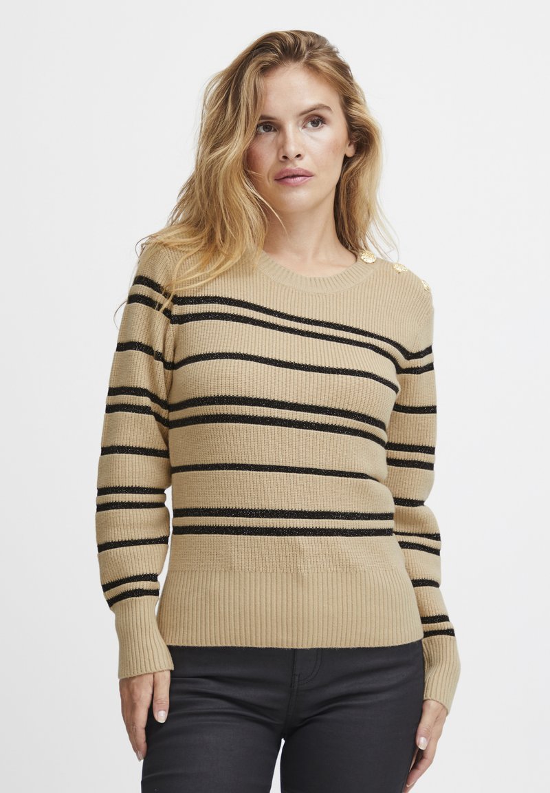 Pull en tricot beige avec des rayures horizontales noires, des poignets et un ourlet côtelés, et des boutons décoratifs sur l'épaule. Texture douce.