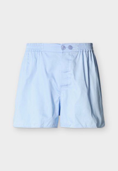 Ανοιχτό μπλε ανδρικό μπόξερ με ελαστική μέση και διπλό κούμπωμα με κουμπιά σε μονόχρωμο φόντο.